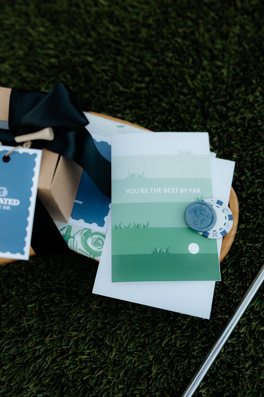 Golf-themed cards and stationery on a grassy surface