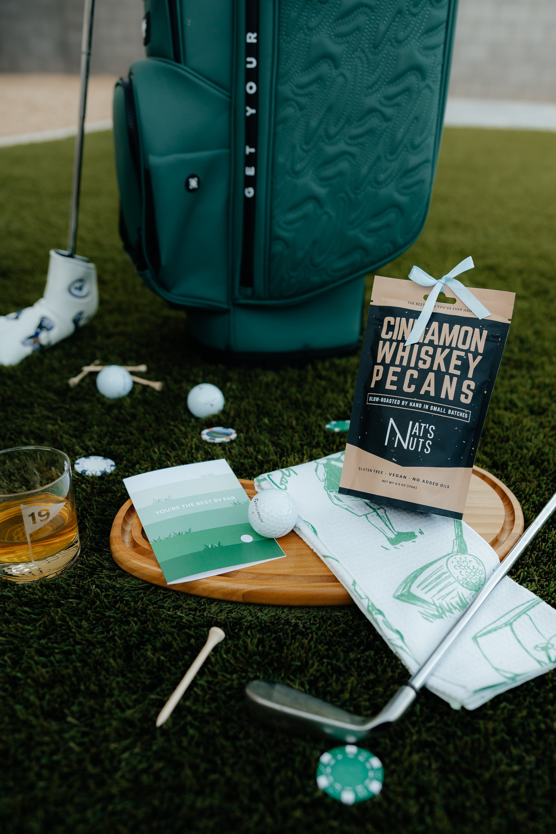 Golf bag, golf clubs, and a snack package on a grassy surface