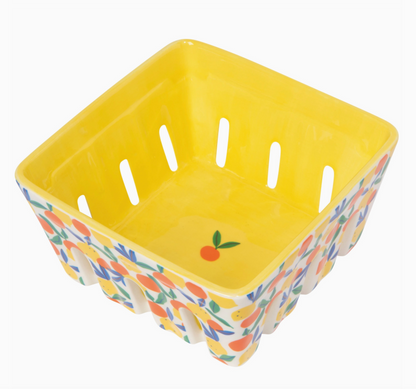 Yellow ceramic basket with floral pattern on a white background