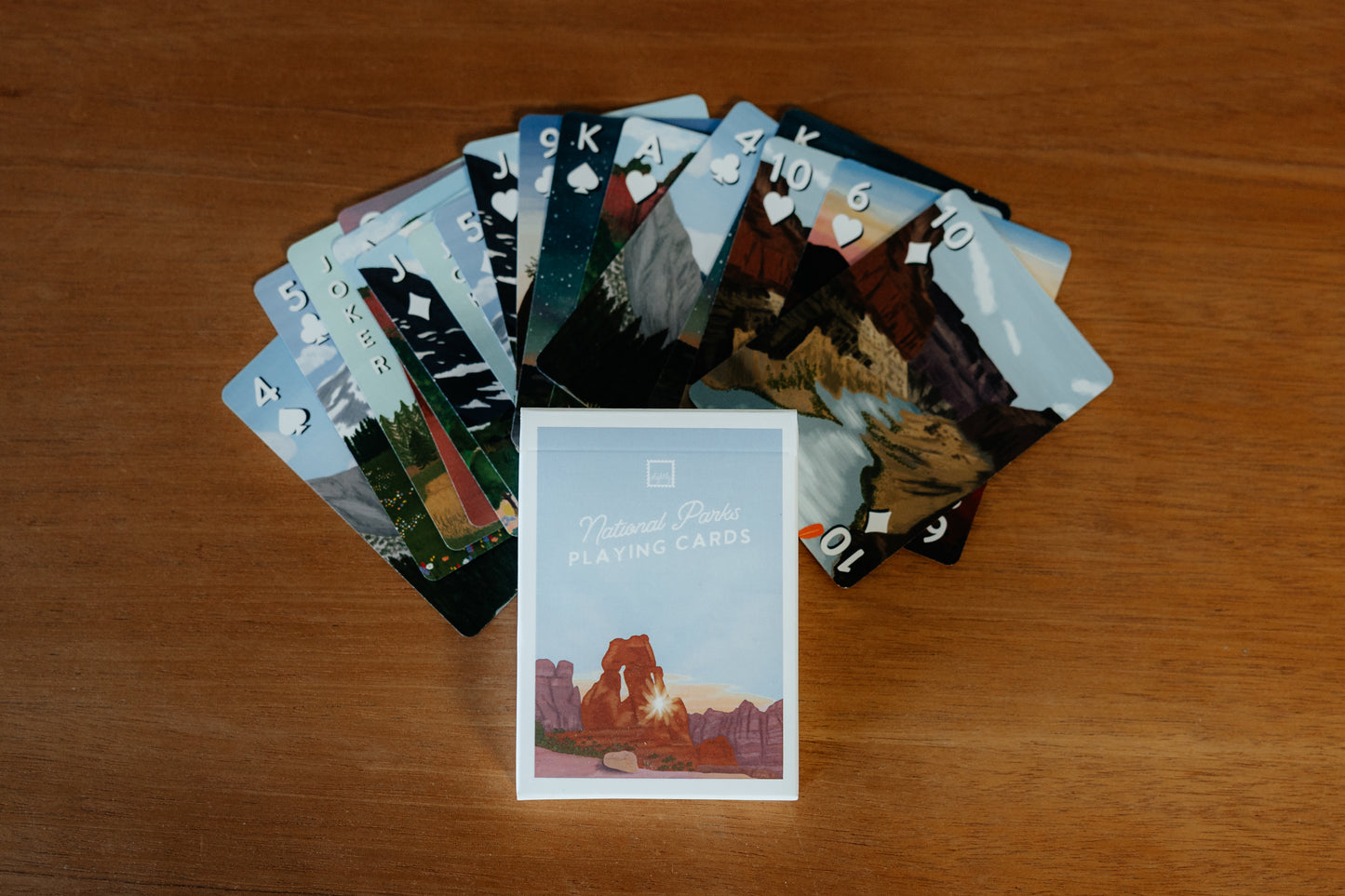 Playing cards with national park-themed artwork on a wooden surface